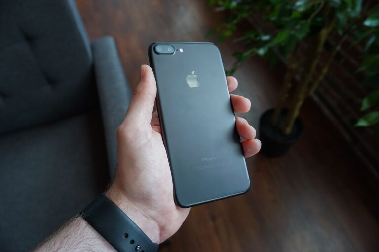 Elinde siyah bir akıllı telefon tutan kişi