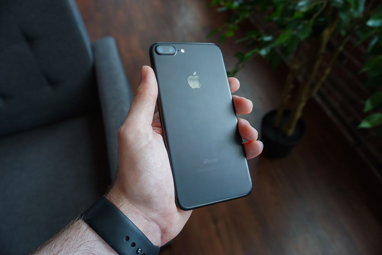 Elinde siyah bir akıllı telefon tutan kişi