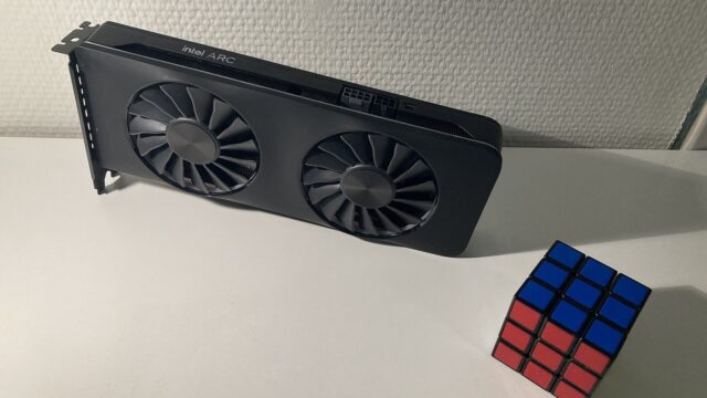 Bir Rubik küpünün yanında duran Intel Arc A770 ekran kartı