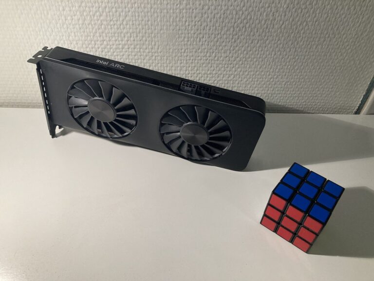 Bir Rubik küpünün yanında duran Intel Arc A770 ekran kartı